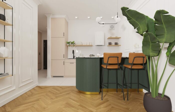 Zielona ryflowana wyspa i rude fotele w mieszkaniu na wynajem w lodzi.